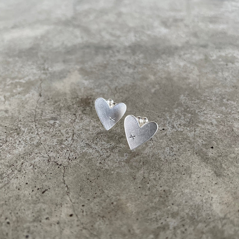 tiny matte sterling silver heart posts with small x detail.